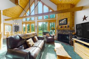 a living room with a leather couch and a television at Cinnamon Teal Chalet in Redmond