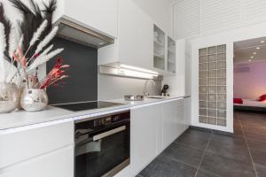 - une cuisine avec des placards blancs et un évier dans l'établissement Village Naturiste R4N - Villa Sonja Heliovillage 2-4 personnes, au Cap d'Agde