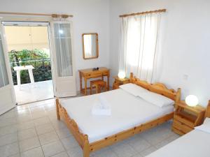 a bedroom with a bed and a balcony at Katerina Apartments in Tsoukaladhes