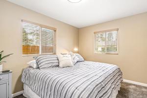 a bedroom with a bed and two windows at Bungalow on Boyd in Coeur d'Alene