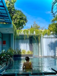 una mujer sentada en una piscina en una casa en Sea House Hotels and Apartments en Vung Tau