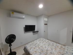 a bedroom with a bed and a flat screen tv at Apartaestudio Cartagena in Cartagena de Indias