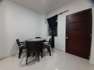 comedor con mesa, sillas y puerta en Apartaestudio Cartagena, en Cartagena de Indias
