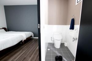 uma casa de banho com uma cama, um WC e um lavatório. em MONOCHROME -SEVEN Hotels and Resorts- em Yomitan