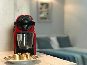 a red blender on a table with a plate of gold capsules at Studio Cozy - In the Heart of Skyros Village in Skiros