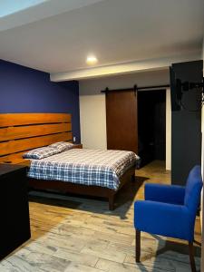 una camera con letto e sedia blu di Casa Dos Fridas - Centro Guanajuato a Guanajuato