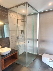 a bathroom with a glass shower and a sink at Chateau Woods in Kalpetta