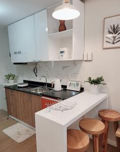 a kitchen with white cabinets and a white counter top at SHERISSE' CONDO @ THE LOOP WITH WIFI,CABLE AND HOT & COLD SHOWER, in Cagayan de Oro
