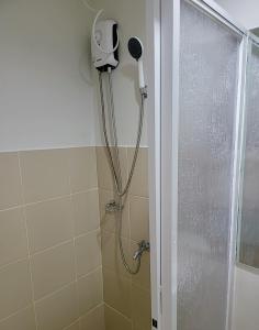 a shower with a blow dryer in a bathroom at SHERISSE' CONDO @ THE LOOP WITH WIFI,CABLE AND HOT & COLD SHOWER, in Cagayan de Oro