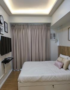 a bedroom with a large bed and a window at SHERISSE' CONDO @ THE LOOP WITH WIFI,CABLE AND HOT & COLD SHOWER, in Cagayan de Oro