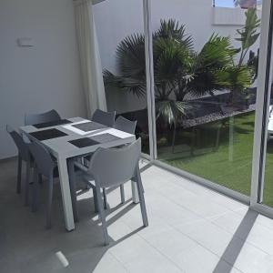 un tavolo bianco e sedie in una stanza con una finestra di Bruna's house ad Adeje