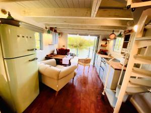 a kitchen and living room in a tiny house at Gorgeous Bruton Chic Lakeside Boat House. in Bruton