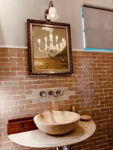 a bathroom with a large wooden sink on a brick wall at Gorgeous Bruton Chic Lakeside Boat House. in Bruton