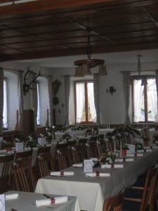 uma grande sala com mesas, cadeiras e janelas em Sonnenkaiser em Fischbachau