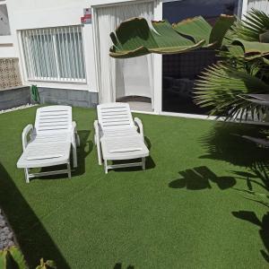 due sedie bianche su un prato con erba verde di Bruna's house ad Adeje