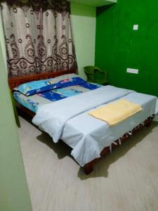 Cama pequeña en habitación con cortina en Yelagiri RAM Cottage @Home with kitchenette full, en Yelagiri