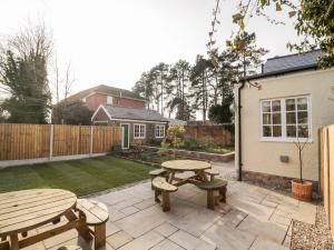 un patio con due tavoli da picnic in un cortile di Station Masters Cottage a Kidderminster