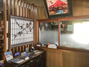 Habitación con escritorio, ventana y pantalla. en Wafu Guesthouse Kashiwaya en Fujikawaguchiko