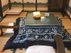 a table with a bowl of oranges on top of it at Wafu Guesthouse Kashiwaya in Fujikawaguchiko