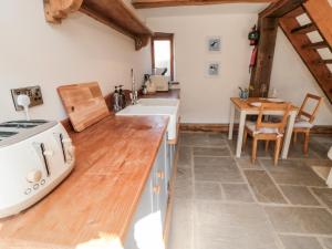 a kitchen with a counter with a sink and a table at The Potting Shed in Scarborough