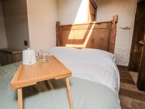 a bed with a wooden head board and a wooden table at The Potting Shed in Scarborough