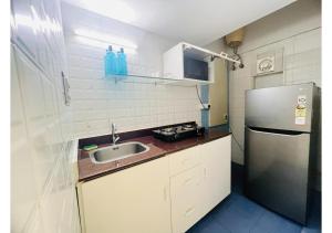 una pequeña cocina con fregadero y nevera. en BluO 1BHK Salt Lake - Kitchen, Balcony, Parking ,Terrace, en Calcuta