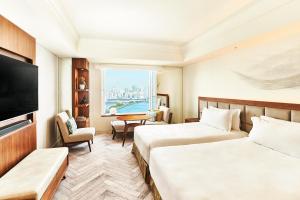 una camera d'albergo con due letti e una televisione di InterContinental Tokyo Bay, an IHG Hotel a Tokyo