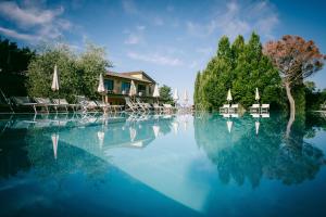 uma grande piscina de água azul com cadeiras e guarda-sóis em Usignoli Studio With Pool em Reggello