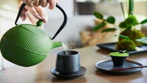 a person pouring water from a tea pot into a cup at InterContinental Tokyo Bay by IHG in Tokyo