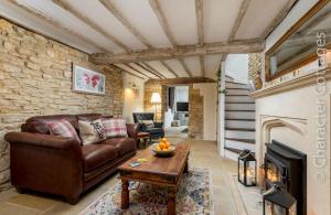 a living room with a couch and a fireplace at Eastnor in Moreton in Marsh