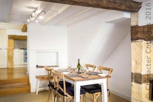a dining room with a white table and chairs at The Brew House in Chipping Campden