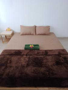 a bedroom with a bed with a green blanket on it at A&B Homestay and Kitchen in Nusa Dua