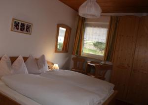 - une chambre avec un lit blanc et une fenêtre dans l'établissement Reiterhof Edelweiss, à San Genesio Atesino