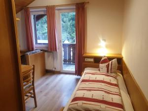 a small bedroom with a bed and a window at Reiterhof Edelweiss in San Genesio Atesino