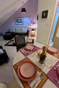 a dining table with red plates and wine glasses at Bellino penthouse in Korčula