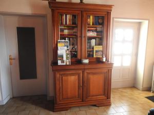 a large wooden cabinet with books in it in a room at Domaine des Gardette in Vaux-en-Beaujolais