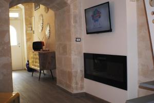 a living room with a fireplace and a tv at La Perla dei Sassi in Matera
