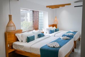 a bedroom with two beds with blue and white pillows at Montagne Residence in Kampot