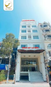 un edificio blanco con un cartel en la parte delantera en Khách Sạn Lạc Hồng Mỹ Tho - Lac Hong My Tho Hotel, en Mỹ Tho