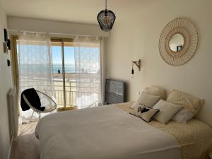une chambre avec un lit avec vue sur l'océan dans l'établissement Appartement Le Marbella, à Les Sables-dʼOlonne