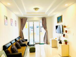 a living room with a couch and a tv at Luxury Cookies Apartment Vung Tau Gold Sea Melody in Vung Tau