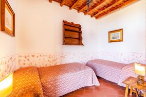 a room with two beds and a table at Usignoli Apartments - Happy Rentals in Reggello