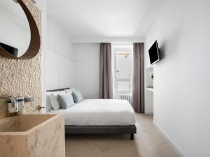 a bedroom with a bed and a mirror and a sink at Numa Rome Tullo in Rome