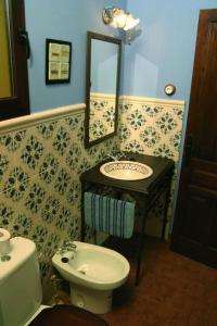 Un baño con lavabo, inodoro y espejo. en Villa Rural Sierra Hueznar, en El Pedroso