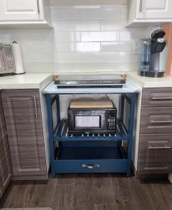 a kitchen with a blue island with a microwave at Suite Sunrise in Vancouver