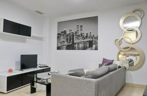 ein Wohnzimmer mit Sofa und Fernseher in der Unterkunft Apartamento San Sebastián in Conil de la Frontera