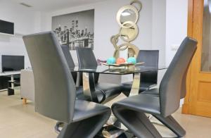 ein Esszimmer mit einem schwarzen Tisch und Stühlen in der Unterkunft Apartamento San Sebastián in Conil de la Frontera