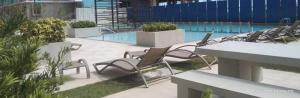 a group of chairs sitting next to a swimming pool at B2B Condo, MARINA SPATIAL - Dumaguete in Dumaguete