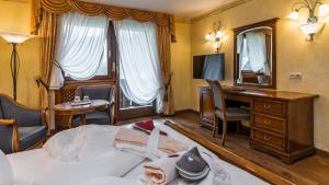 a hotel room with a table, chairs and a coffee table at Romantik Hotel Santer in Dobbiaco