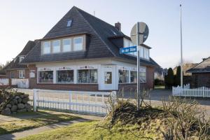 una casa con un letrero de la calle delante de ella en An der Düne 2, Whg 1, en Hörnum